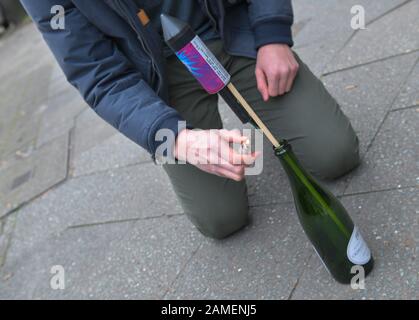 Start einer Silvesterrakete aus einer Flasche Stockfoto