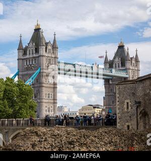 London, Großbritannien - 7. Juni 2017: Touristen gehen an den Wänden des Tower of London entlang und genießen den Blick auf die berühmte Tower Bridge. In der Stadt Stockfoto