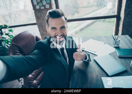 Nahaufnahme des Fotoporträts eines coolen Managers, der selfie bei der Arbeit am Tisch sitzend mitnimmt Stockfoto