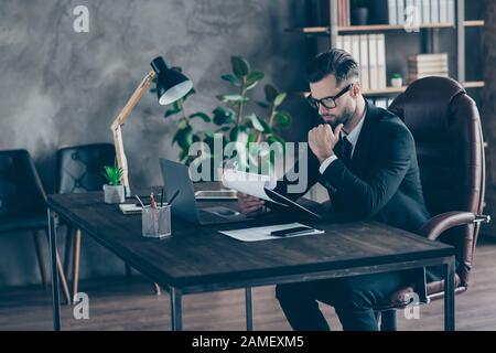 Profilfoto von gut aussehenden Geschäftstelefin Lesen Papier Bericht halten Hand am Kinn nachdenkliche wichtige Dokumente tragen Spezifikationen schwarze Blazer Hemdanzug Stockfoto