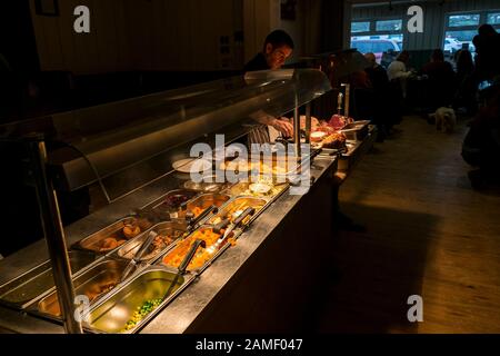 Ein Koch, der an einem Sonntags-Mittagessen in einem Pub arbeitet. Stockfoto