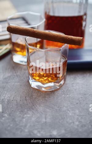 Karaffe von Whiskey oder Brandy, Brille und Schachtel finnest kubanischer Zigarren Stockfoto