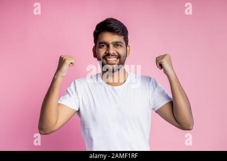 Menschen, Erfolg, Sieg, gute Nachrichten und Feier. Glückliche erfolgreiche junge indische Männer, die die Hände hochheben, Fäuste im Triumph festsetzen, den Sieg feiern, wir Stockfoto