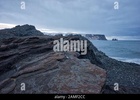 An einem trüben Morgen in Island dehnten sich die Felsen über die Küste aus Stockfoto