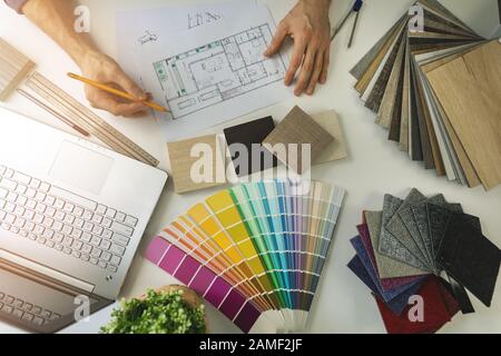 Designer, der im Büro arbeitet und Möbel- und Bodenbeläge aus Proben für Innenraumgestaltung auserlese. Draufsicht Stockfoto