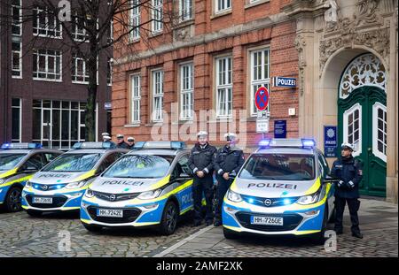 13. Januar 2020, Hamburg: Polizeibeamte stehen neben elektrisch angetriebenen Funkpatrouillenwagen vor der Außenstelle des polizeikommissariats 14. Die rein elektrisch angetriebenen Funkpatrouillenwagen sollen laut Polizei vor allem zur Verkehrsraumüberwachung eingesetzt werden. Foto: Christian Charisius / dpa Stockfoto