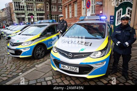 13. Januar 2020, Hamburg: Polizeibeamte stehen neben elektrisch angetriebenen Funkpatrouillenwagen vor der Außenstelle des polizeikommissariats 14. Die rein elektrisch angetriebenen Funkpatrouillenwagen sollen laut Polizei vor allem zur Verkehrsraumüberwachung eingesetzt werden. Foto: Christian Charisius / dpa Stockfoto