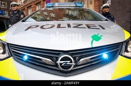 13. Januar 2020, Hamburg: Polizeibeamte stehen neben einem Funkpatrouillenwagen mit Elektroantrieb vor der Außenstelle des polizeikommissariats 14. Die rein elektrisch betriebenen Funkpatrouillenwagen sollen laut Polizei vor allem zur Verkehrsraumüberwachung eingesetzt werden. Foto: Christian Charisius / dpa Stockfoto