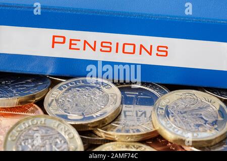 Renten Sparportfolio Ordner auf einem Haufen von Pfund Sterling Geld neue £ Pfund Münzen. Zur Veranschaulichung des Sparens für ein Rentenkonzept. England Großbritannien Stockfoto