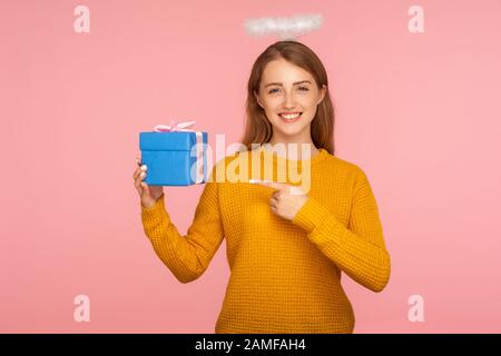 Schau mir mein Geschenk an. Porträt eines schönen Ingwermädchens mit einem Halo über dem Kopf, das zur Zeit zeigt und mit einer Kamera lächelt, die kleine Schachtel zeigt. I Stockfoto