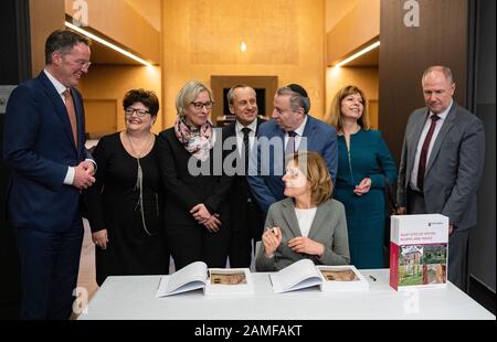 13. Januar 2020, Rheinland-Pfalz, Mainz: Michael Ebling (l-r, standing, SPD), Mainzer Oberbürgermeisterin Anna Kirschner, Vorsitzende der Jüdischen Gemeinde Mainz, Stefanie Seiler (SPD), Oberbürgermeister von Speyerer, Konrad Wolf (SPD), rheinland-pfälzische Kultusministerin Avadislav Awadiev, Vorsitzender des Jüdischen Landesverbandes Rheinland-Pfalz Marina Nikiforova, Jüdische Kultusgemeinde Rheinland-Pfalz, und Adolf Kessel (CDU), Oberbürgermeister von Worms, blicken auf die Schulter von Malu Dreyer (SPD), Ministerpräsident von Rheinland-Pfalz, als sie die UNESCO unterzeichnet Stockfoto