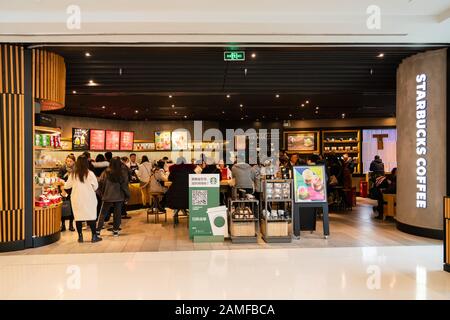 Kunden, die in einem amerikanischen Kaffeeunternehmen und einer Kaffeehauskette Starbucks Store in Shanghai zu sehen sind. Stockfoto