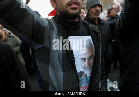 Teheran, Iran. Januar 2020. Ein Mann mit einem Bild des iranischen Befehlshabers Qasem Soleimani auf seinem Hemd besucht einen Protest außerhalb der britischen Botschaft in Teheran, Iran, 12. Januar 2020. Das iranische Außenministerium berief am Sonntag Robert Macaire, den britischen Botschafter im Iran, für das, was es das "ungewöhnliche Verhalten" des Gesandten nannte und "an einer illegalen Versammlung" in Teheran teilnahm. Iranische Beamte hielten Macaire am Samstag inmitten einer regierungsfeindlichen Versammlung außerhalb einer Universität in Teheran fest. Er wurde etwa eine Stunde später freigelassen. Kredit: Ahmad Halabisaz/Xinhua/Alamy Live News Stockfoto