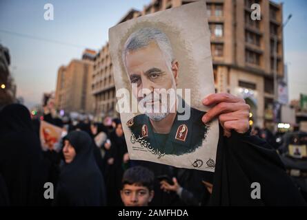 Teheran, Iran. Januar 2020. Ein Protestler hält ein Bild des iranischen Befehlshabers Qasem Soleimani während eines Protestes außerhalb der britischen Botschaft in Teheran, Iran, 12. Januar 2020. Das iranische Außenministerium berief am Sonntag Robert Macaire, den britischen Botschafter im Iran, für das, was es das "ungewöhnliche Verhalten" des Gesandten nannte und "an einer illegalen Versammlung" in Teheran teilnahm. Iranische Beamte hielten Macaire am Samstag inmitten einer regierungsfeindlichen Versammlung außerhalb einer Universität in Teheran fest. Er wurde etwa eine Stunde später freigelassen. Kredit: Ahmad Halabisaz/Xinhua/Alamy Live News Stockfoto