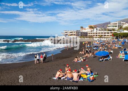 Menschen in Santa Hüte Strand Playa de la Arena, Puerto de Santiago, Teneriffa, Kanarische Inseln, Spanien Stockfoto