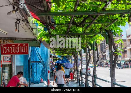 Bangkok, Thailand - 29. November 2019: Fußgänger, die auf einem schattigen Seitenspaziergang in bangkok spazieren Stockfoto