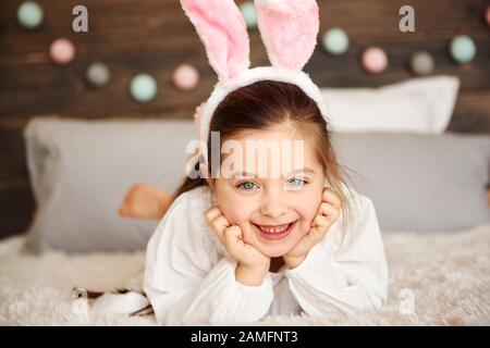 Lächelndes Mädchen, das auf dem Bett liegt Stockfoto