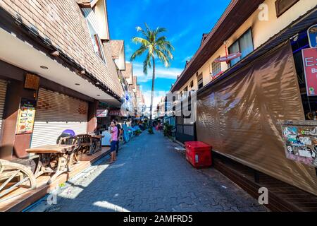 Phi Phi, Thailand - 26. November 2019: Geschäft auf beiden Seiten der schmalen Gasse in Phi Phi Island, Thailand. Stockfoto