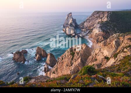 Sintra, Portugal. Praia da Ursa oder Ursa Beach eindrucksvolle einzigartige Küstenstapel und Klippen am Abend Sonnenuntergang Licht an der Atlantikküste Stockfoto