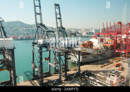 HongKong, China - November 2019: Kräne laden Shipping Container auf Fracht Hafen Logistik Zentrum in Hongkong Stockfoto