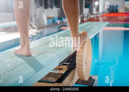 3/4-Blick auf Schwimmer, die auf Sprungbrett stehen Stockfoto