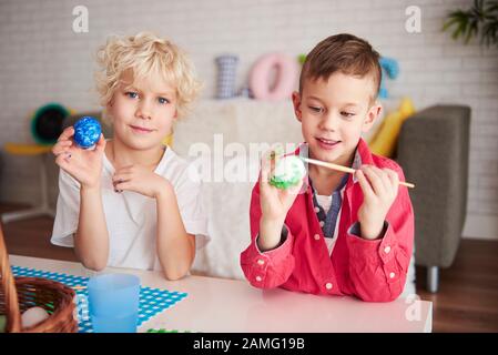 Zwei glückliche Jungen malen Eier für die osterzeit Stockfoto