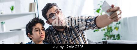 Panoramaaufnahme des jüdischen Vaters, der selfie mit niedlichem Sohn in der Wohnung mitnimmt Stockfoto