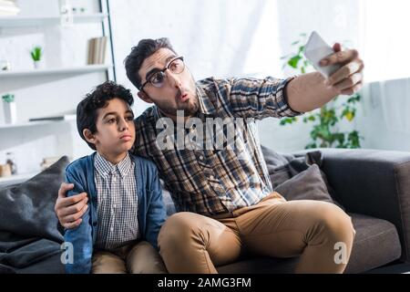 Jüdischer Vater nimmt selfie mit niedlichem Sohn in Wohnung Stockfoto