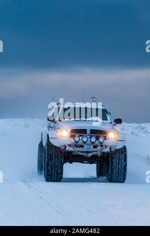 SUV fahren entlang der Straße im Schnee in Island im Januar Stockfoto
