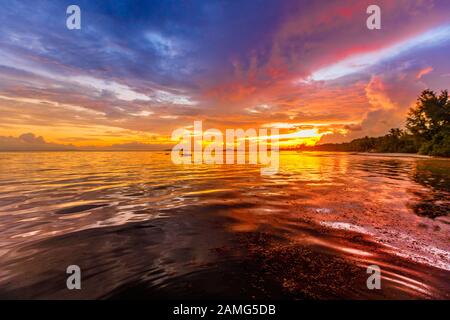 Weiche, flauschige und bunte Wolkenbildung in vielen Farben am Grand Anse Beach, auf der Insel Praslin, auf den Seychellen. Farbenfroher Himmel mit Wolken am Abend Stockfoto