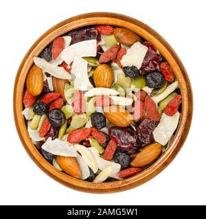 Superfood-Snack-Mix in Holzschale. Trail Mix aus getrockneten Mandeln, Preiselbeeren, pepitas, Kokospänen, Blaubeeren und Goji-Beeren. Stockfoto