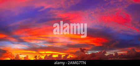 Dramatisches Bannerpanorama der Wolkenlandschaft im Zwielicht mit Sonnenuntergang. Weiche, flauschige und bunte Wolkenbildung in vielen Farben. Farbenfroher Himmel mit Wolken Stockfoto