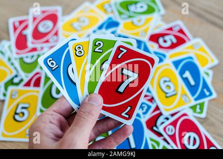 Kiew, UKRAINE - 22. NOVEMBER 2019: 3/4-Ansicht des Mannes, der bunte UNO-Spielkarten hält Stockfoto
