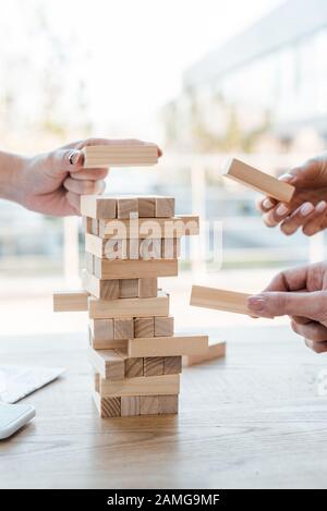 Kiew, UKRAINE - 22. NOVEMBER 2019: 3/4-Ansicht von Frauen, die Block-Holz-Tower-Spiel spielen Stockfoto