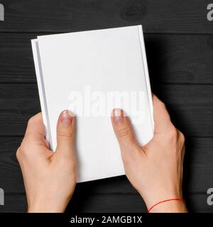 Männer halten geschlossenes Buch mit leerem Cover auf hellem Hintergrund Stockfoto