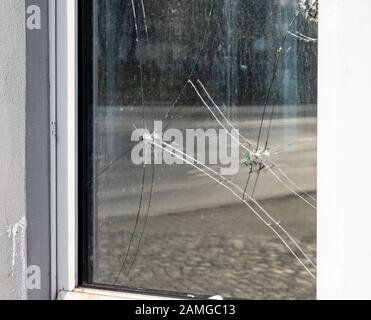 Einschusslöcher in einem Fensterausschnitt Stockfoto