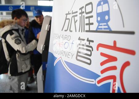 (200113) -- LANZHOU, 13. Januar 2020 (Xinhua) -- Freiwillige helfen einem Passagier, seinen vorläufigen Personalausweis am Bahnhof Lanzhou in Lanzhou, der Hauptstadt der nordwestchinesischen Provinz Gansu, am 13. Januar 2020 auszudrucken. Während der Reiseströme des Frühlingsfestes wurde am Bahnhof Lanzhou und am Westbahnhof von Lanzhou ein spezieller Freiwilligendienst mit dem Namen "Wegwerf der Reise" veranstaltet. Für Fahrgäste, die Termine gemacht haben, die in Eile sind, um in die Züge zu kommen oder das mobile Ticketsystem nicht kennen, sind Freiwillige da, um Dienst zu leisten und ihnen zu helfen, die Zeit des Zugs zu verkürzen, Bringin Stockfoto