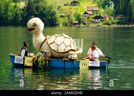 Bad Aussee, Österreich - 30. Mai 2005: Nicht identifizierte Menschen im Boot mit blumenverzierter Skulptur beim jährlichen Festival der Narzissen am Grundlsee Stockfoto