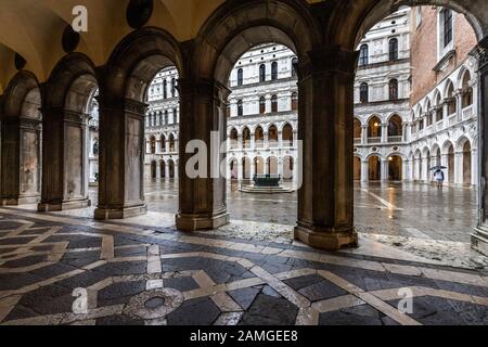 Blick durch die Bögen in den Innenhof des Dogenpalastes in Venedig, wo der nordbronzene Brunnen zu sehen ist. Stockfoto