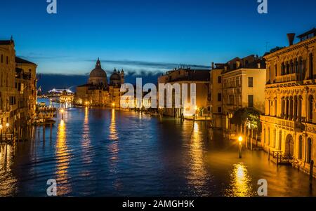 Blick am frühen Morgen von der Accademia-Brücke, die auf dem Canal Grande Richtung Osten blickt, Richtung Salute mit Kreuzfahrtschiff im Hintergrund, das Venedig verlässt. Stockfoto