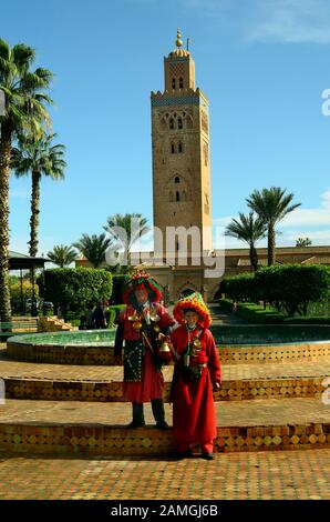 Marrakesch, Marokko - 23. November 2014: Nicht identifizierter Wasserträger in ihrer traditionellen Tracht mit Ausrüstung vor der Koutoubia-Moschee Stockfoto