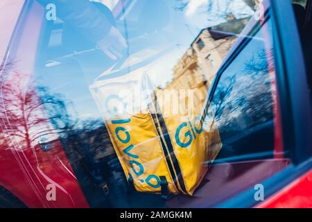 Lemberg, Ukraine- 13. Januar 2020: Glovo Liefertasche im Auto. Mann Arbeiter nimmt thermobag. Lieferfirma Stockfoto