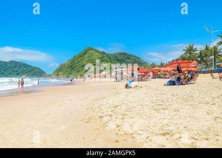 Guaruja - SP, Brasilien - 20. November 2019: Schöner Brasilienstrand an der Paulista-Küste an einem sonnigen Tag. Sonnenbäder, Sonnenschirme und die wunderbare Aussicht Stockfoto