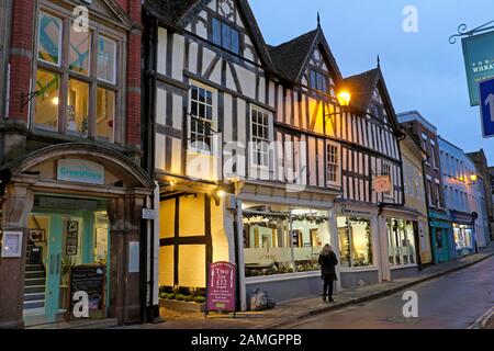 Eine Person, die vor der Vergangenheit spazieren ging, zündete zu Weihnachten in einer Straße in der Stadt Shrewsbury Shropshire, England, Großbritannien KATHY DEWITT, die Gaslampe Shopfront an Stockfoto