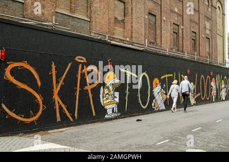 London, Großbritannien - 20. Juli 2019: Ein mit Figuren und Schriftzügen des Straßenkünstlers Nathan Bowen dekoriertes Hoarding neben dem Old Vic Theatre in Lambeth, Stockfoto