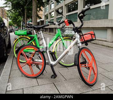 London, Großbritannien - 20. Juli 2019: Mieten Sie Fahrräder der Firmen Lime und Mobike, die auf einem Straßenbelag in Lambeth, London, geparkt sind. Es gibt Bedenken, dass einige bi Stockfoto