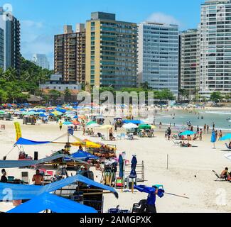 Guaruja - SP, Brasilien - 20. November 2019: Sonnenanbeter am Strand Praia das Pitangueiras, dem wichtigsten städtischen Strand der Stadt. Stockfoto