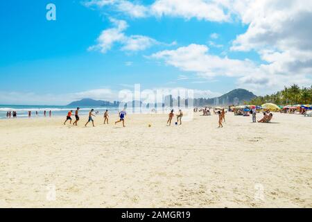 Guaruja - SP, Brasilien - 20. November 2019: Kinder, die am Strand Fußball spielen. Strand Enseada - Praia da Enseada. Stockfoto