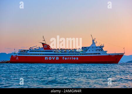 Ägina, Griechenland - 15. September 2019: Fährschiff am Hafen von Ägina in der Dämmerung. Schiff: Nova Ferries, "Phivos" Stockfoto