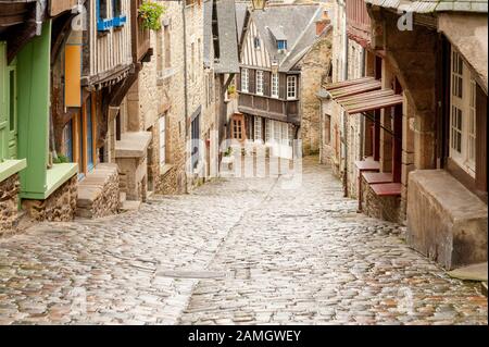 Mittelalterliche Kopfsteinpflasterstraße Rue du Jerzual mit Holzhäusern und Geschäften im historischen Dinan, Bretagne, Frankreich Stockfoto